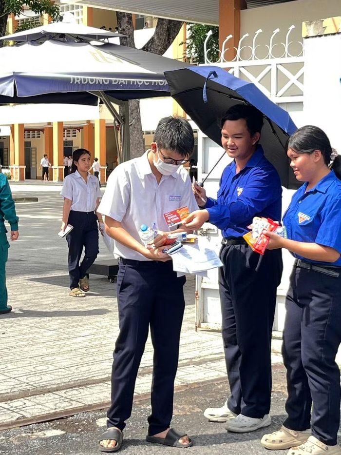 Các bạn tình nguyện viên hỗ trợ thí sinh tại cổng trường.