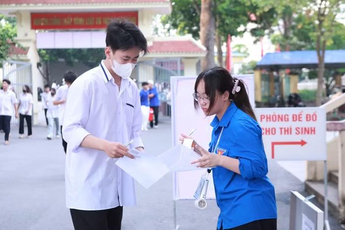 Các tình nguyện viên tại Điểm thi Trường THPT Kim Động, Hưng Yên hướng dẫn thí sinh gửi đồ tư trang bên ngoài phòng thi.