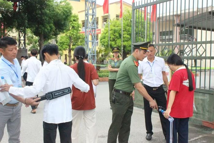 Lực lượng an ninh sử dụng máy quét cầm tay kiểm tra an ninh tại các cổng Điểm thi.