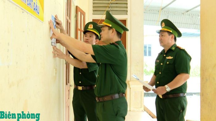 Cán bộ Đồn Biên phòng Tam Hợp dán tờ rơi được in mã QR tại nhà văn hóa bản Phá Lõm. Ảnh: Hải Thượng