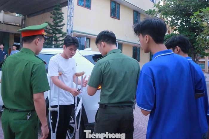 Công an xã Đô Lương hỗ trợ nam sinh Nguyễn Tuấn Tú chống nạng đi thi.
