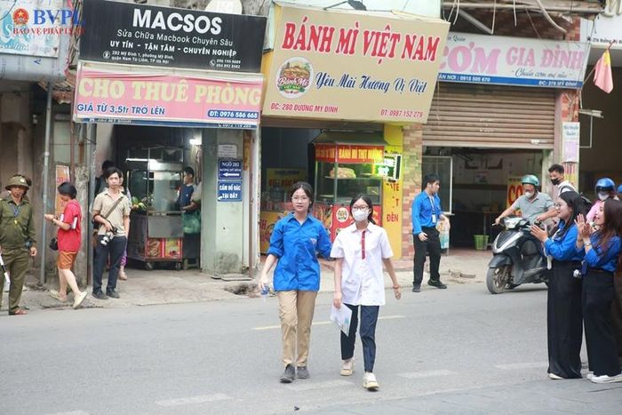 Sinh viên tình nguyện hỗ trợ các em thí sinh sang đường.