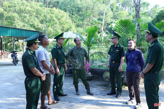 Ông Đoàn Lê Anh (người đứng giữa) - Trưởng thôn 5, xã Sơn Hồng trao đổi với cán bộ Đồn Biên phòng Sơn Hồng về tình hình địa bàn.