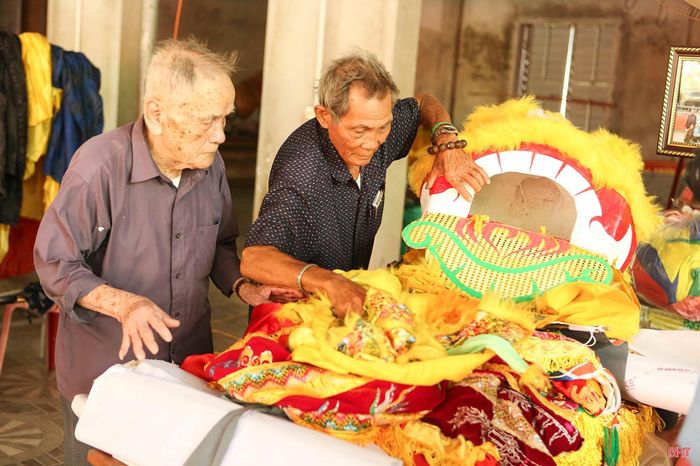 Cụ Lê Xuân Hoan (bên trái, trú thôn Tân Phong, xã Thạch Khê) cùng thành viên Ban Lễ nghi đền Nước Lạt soát lại đồ phục vụ rước lễ.