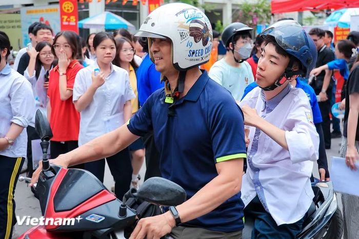 Anh Đinh Danh Lâm (46 tuổi, sống tại Định Công) ân cần chăm sóc con trai Đinh Thanh Sơn trong kỳ thi Trung học phổ thông với niềm tin và hy vọng dành cho con như cách anh đã làm 18 năm qua. (Ảnh: Hoài Nam/Vietnam+)