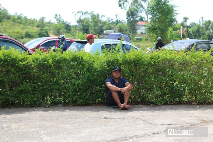Một phụ huynh tìm bóng cây ngồi chờ, không gian khá yên ắng nhưng lại chứa đựng rất nhiều cảm xúc.