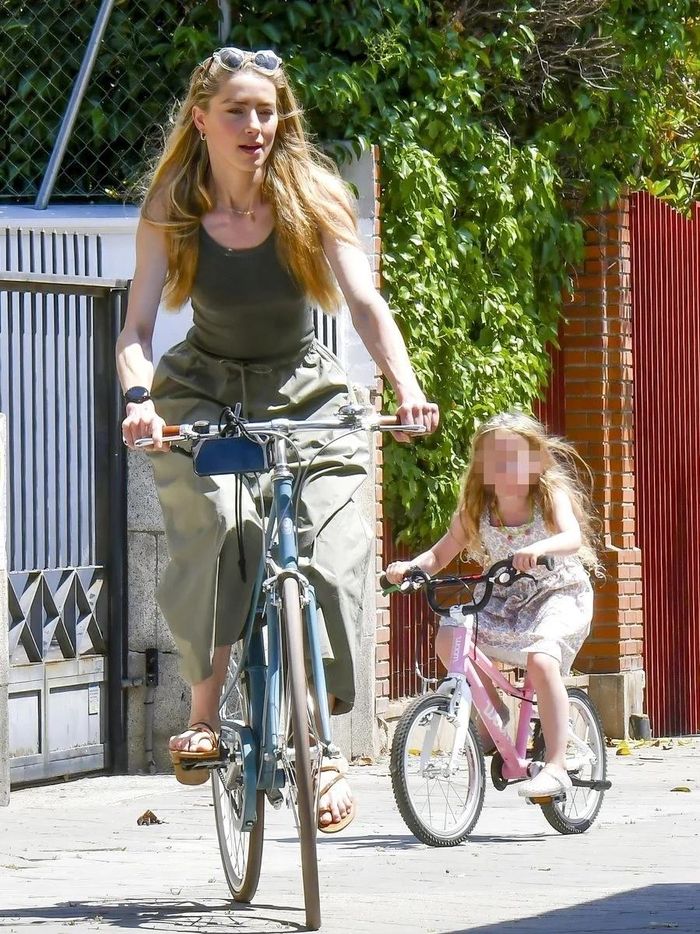 Amber Heard đạp xe cùng con gái tại một con phố ở Madrid.
