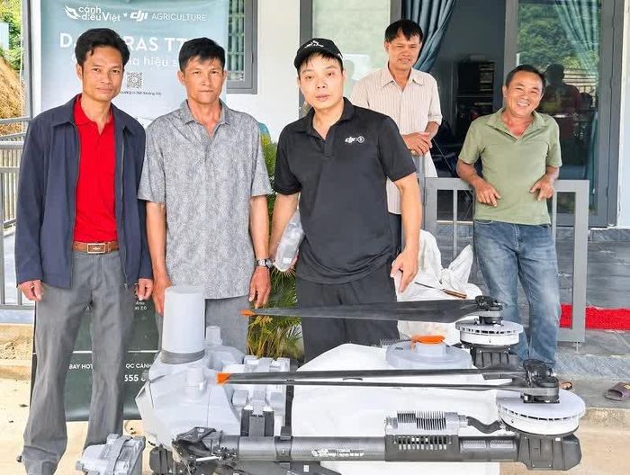 Ông Trần Tấn Hưng - Phó trưởng Phòng Kinh tế xã Đam Rông 2 (bìa trái), thay mặt UBND xã bàn giao mô hình cơ giới hóa (máy bay không người lái DJI AGRAS T70P) cho Tổ hợp tác Sầu riêng Đạ Tồn, thôn Bằng Lăng. 