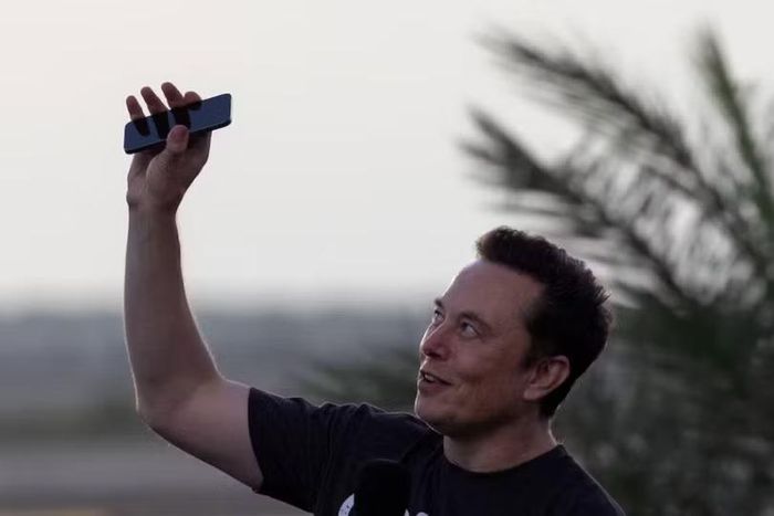 Elon Musk giơ điện thoại lên trời trong cuộc họp báo chung với CEO của T-Mobile, Mike Sievert tại trạm không gian SpaceX Starbase, ở Brownsville, Texas, Mỹ, ngày 25/8/2022. Ảnh: Reuters.