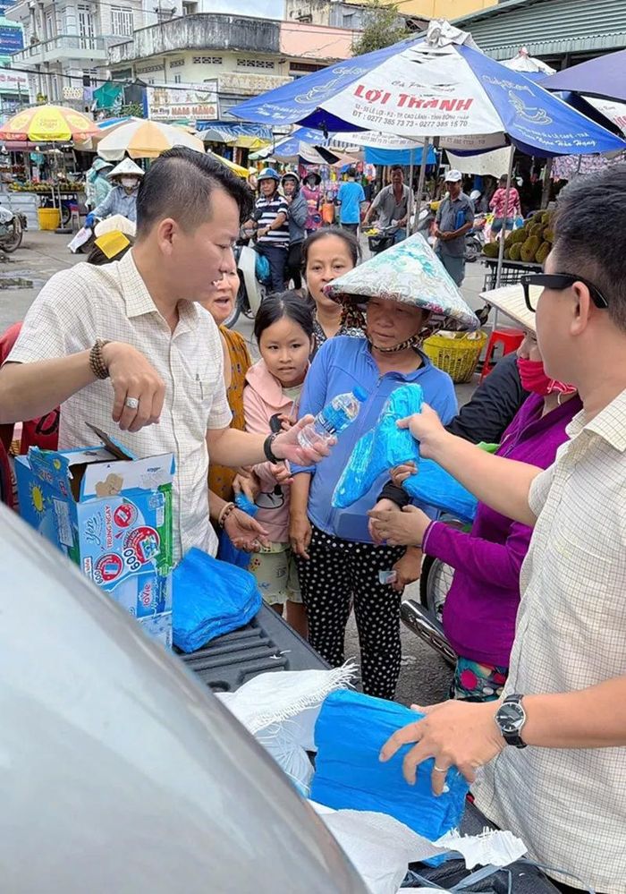 Các thành viên của Công ty XSKT Hậu Giang tặng quà cho người khó khăn ở Vĩnh Long