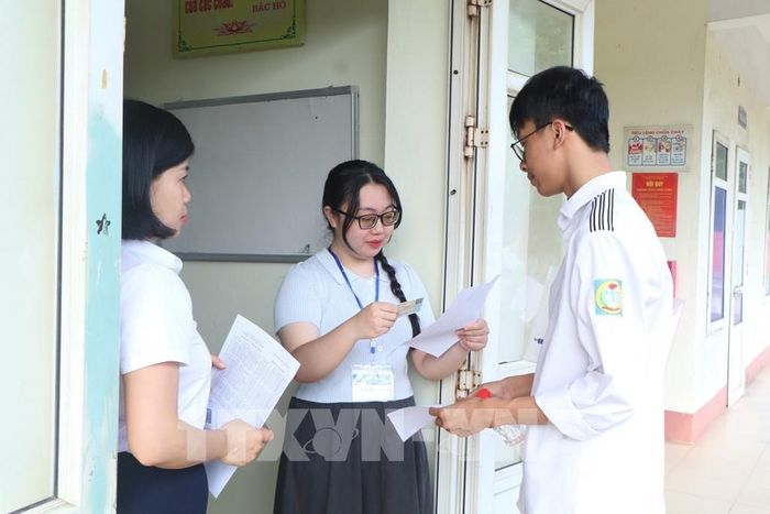 Giám thị tại điểm thi trường THPT Việt Trì (phường Việt Trì) kiểm tra thông tin thí sinh trước khi vào phòng thi. Ảnh: Thu Hương – TTXVN 