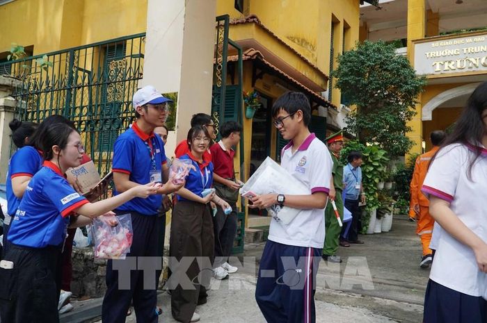 Tình nguyện viên hỏi thăm, động viên thí sinh sau khi hoàn thành kỳ thi. Ảnh: Thu Hoài - TTXVN