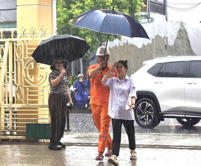 Một trong những hình ảnh ấn tượng và xúc động nhất được người dân, phụ huynh chia sẻ trên mạng xã hội là khoảnh khắc các nhân viên điện lực che ô đưa thí sinh vào tận phòng thi.