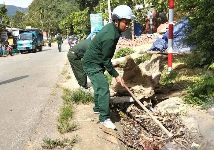 Các lực lượng xã Bến Hiên xúc dọn rác thải ở mương thoát nước. Ảnh: CCB