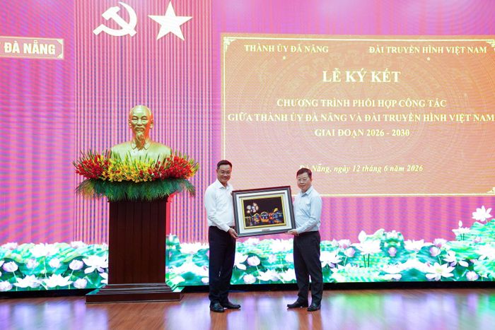 Bí thư Thành ủy Lê Ngọc Quang tặng quà lưu niệm cho Tổng Giám đốc VTV Nguyễn Thanh Lâm. Ảnh: THÀNH CÔNG