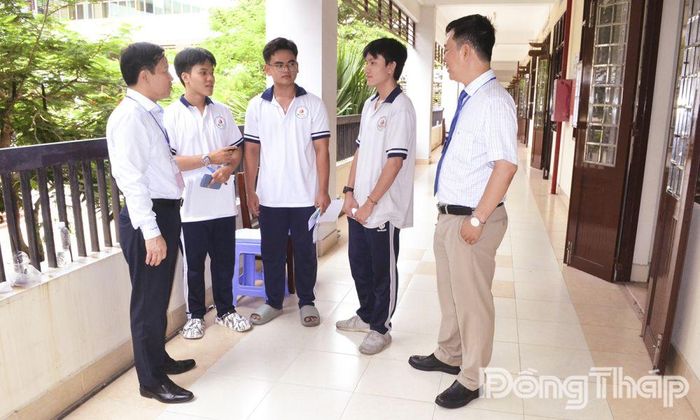 Tiến sĩ Lê Quang Trí, Giám đốc Sở Giáo dục và Đào tạo tỉnh Đồng Tháp (bìa trái) thăm hỏi, động viên thí sinh sau khi hoàn thành ngày thi cuối.