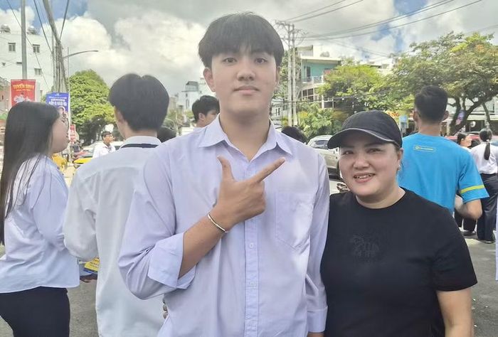  Em Nguyễn Hoàng Nam được mẹ đón tại điểm thi Trường THPT số 2 Phan Bội Châu. Ảnh: Ngọc Sang 