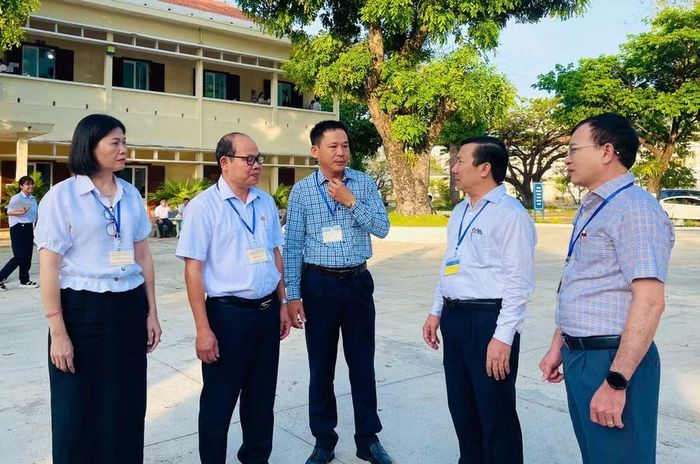  Ông Phạm Văn Nam (thứ 2 bên phải qua) kiểm tra công tác tổ chức thi tại điểm thi Trường THPT Quốc học Quy Nhơn. Ảnh: Trần Dung 