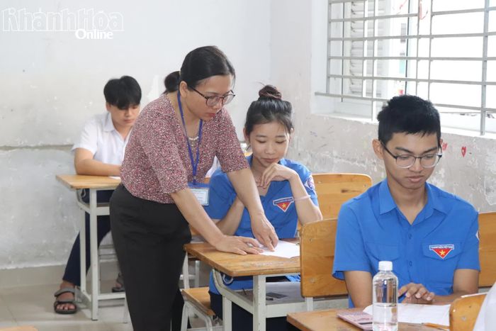Giám thị coi thi rà soát thông tin cá nhân của thí sinh và ký vào giấy thi.