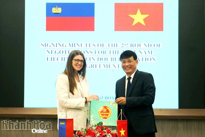 Trường Đoàn đàm phán Việt Nam Đặng Ngọc Minh trao quà cho đại diện đoàn đàm phán Lích-then-xtai-in.