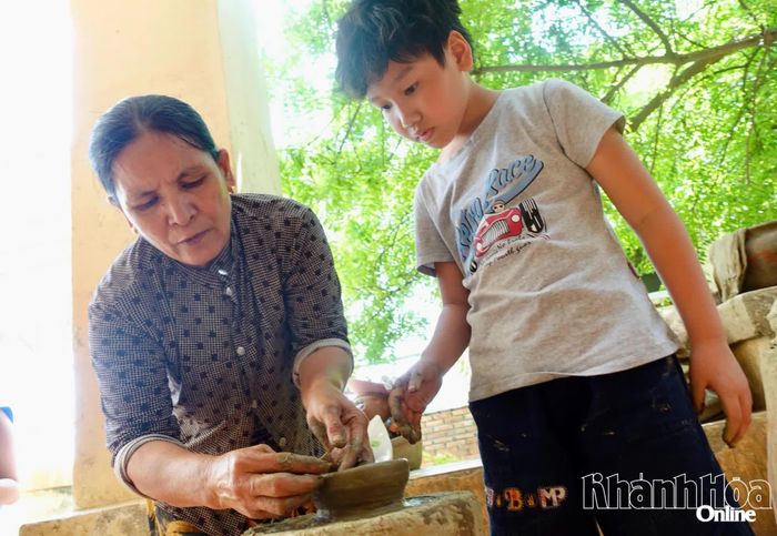 Bà Đàng Thị Liễu tận tình hướng dẫn các bạn nhỏ cách làm gốm.