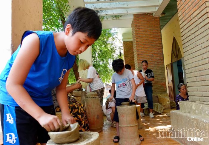 Em Minh Khang tập trung để tạo hình và trang trí lên món quà kỷ niệm của mình.