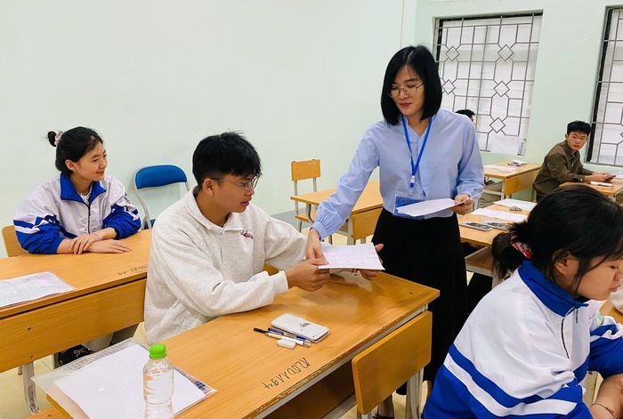 Giám thị phát phiếu trả lời trắc nghiệm cho thí sinh trước giờ phát đề thi tại điểm thi Trường Phổ thông Dân tộc nội trú THPT tỉnh.
