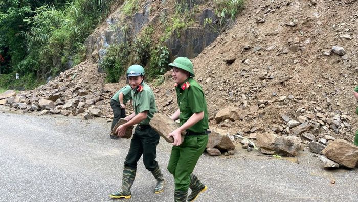 Cán bộ, chiến sĩ Công an xã Khao Mang thu dọn đá lăn, đảm bảo an toàn cho người và phương tiện tham gia giao thông.