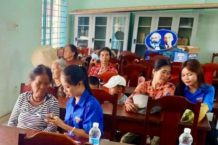 Lực lượng thanh niên hỗ trợ người dân thực hiện các thao tác trên điện thoại thông minh