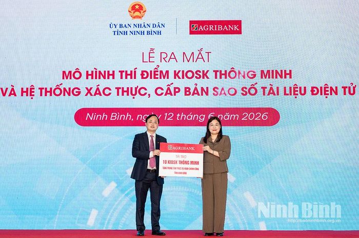 Đồng chí Tô Huy Vũ, Chủ tịch Hội đồng thành viên Agribank Việt Nam trao biểu trưng 10 Kiosk Hành chính công thông minh cho đồng chí Hà Lan Anh, Phó Chủ tịch UBND tỉnh Ninh Bình.
