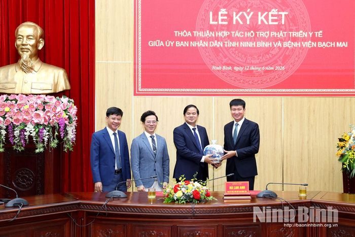 Đồng chí Bí thư Tỉnh ủy Trần Huy Tuấn trao quà lưu niệm cho lãnh đạo Bệnh viện Bạch Mai.