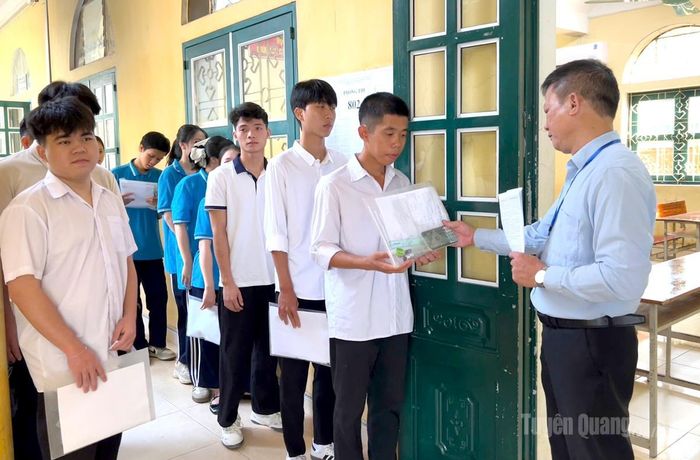 Cán bộ coi thi tại điểm thi trường THPT Ỷ La kiểm tra, đối chiếu thông tin thí sinh trước khi vào phòng thi Ảnh: Thúy Nga