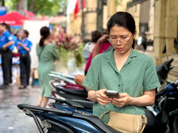 Phụ huynh đứng chờ bên ngoài cổng trường, gương mặt đầy tâm trạng.