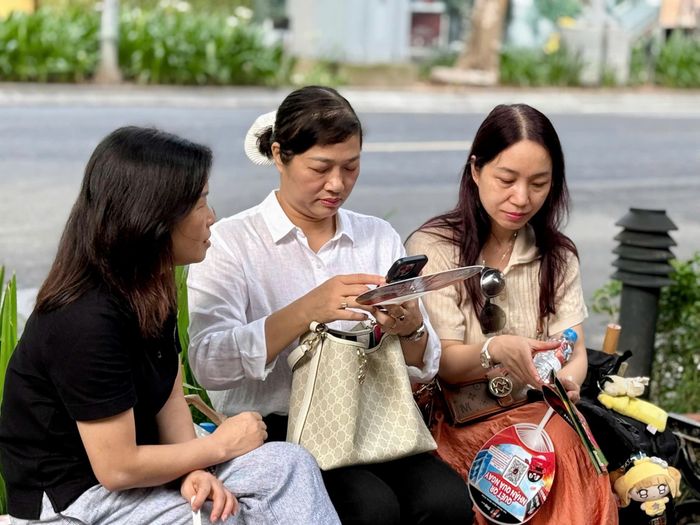 Phụ huynh tại điểm thi Trường THPT Trần Phú – Hoàn Kiếm nán lại bên ngoài cổng trường, gương mặt lo lắng chờ đợi con.