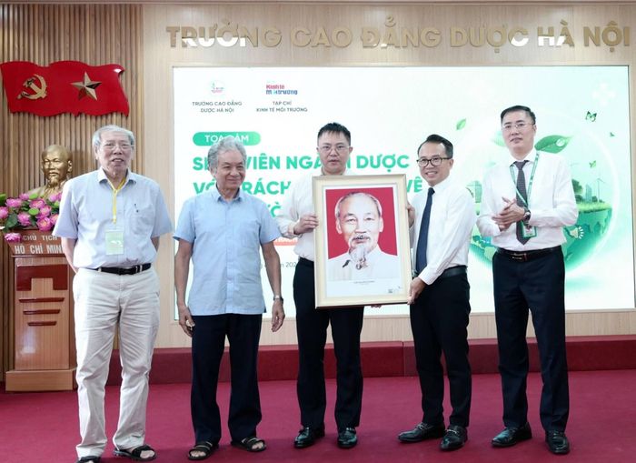  Lãnh đạo Tạp chí Kinh tế Môi trường tặng bức tranh chân dung Hồ Chủ tịch tới Trường Cao đẳng Dược Hà Nội. 