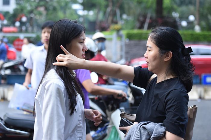 Phụ huynh dặn dò, động viên thí sinh vững tâm làm bài trước khi vào điểm thi tại Trường THCS Thanh Xuân (Phường Thanh Xuân Trung). Ảnh: Xuân Quý