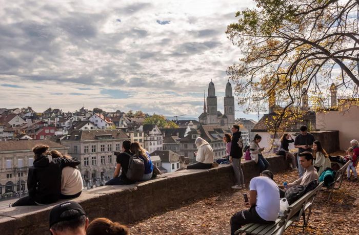 Người dân Thụy Sĩ bên sông Limmat gần Lindenhof ở Zurich. Ảnh: Alamy
