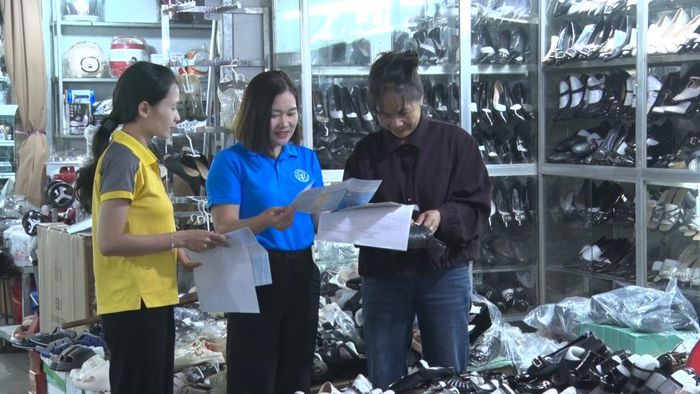 Cán bộ Bảo hiểm xã hội và đơn vị đại lý tuyên truyền chính sách bảo hiểm cho các hộ kinh doanh trên địa bàn phường Thục Phán.