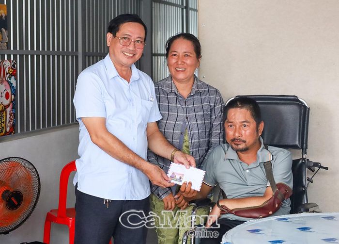 Bác sĩ Trần Văn Hùng, Giám đốc Trạm Y tế Xã Quách Phẩm, trao phần hỗ trợ cho gia đình anh Lê Hoàng Tâm tại lễ bàn giao nhà.