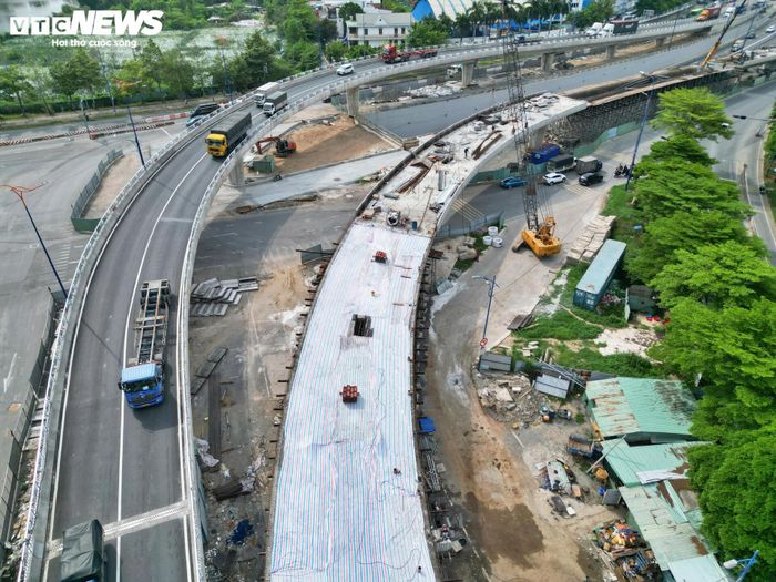 Nhìn từ trên cao, công trường nhánh N4 đang bước vào giai đoạn nước rút. Các mũi thi công đồng loạt triển khai đổ bê tông cốt thép bản mặt cầu, thi công nhịp dẫn kết nối, gờ lan can, hệ thống thoát nước, chuẩn bị thảm nhựa mặt cầu và lắp đặt hệ thống chiếu sáng.