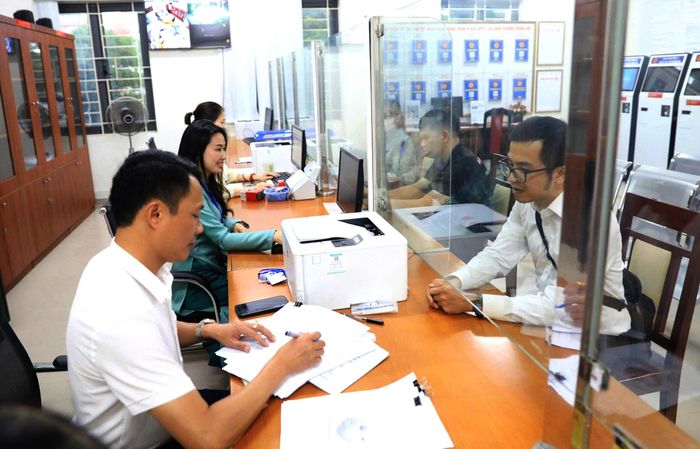 Giải quyết thủ tục hành chính cho người dân tại Điểm phục vụ hành chính công Dương Nội. Ảnh: Quang Thái