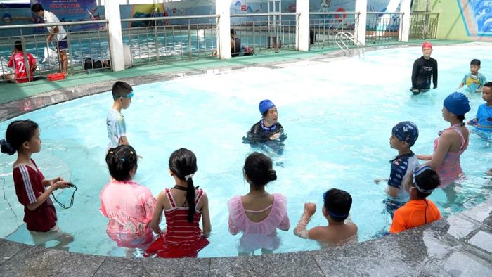 Trẻ em xã Hoài Đức thực hành những động tác kỹ thuật bơi ếch đầu tiên dưới nước. Ảnh: Hương Đỗ
