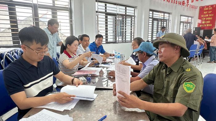 Người dân thôn Quần Hiền có vướng mắc liên quan đến Giấy chứng nhận quyền sử dụng đất được cán bộ chuyên môn giải thích, hướng dẫn. Ảnh: PV