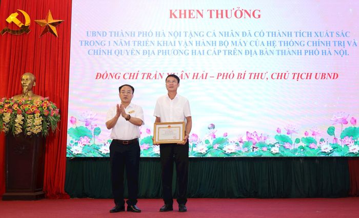 Bí thư Đảng ủy, Chủ tịch HĐND xã Phúc Sơn Phan Văn Sự trao Bằng khen của UBND thành phố tặng Chủ tịch UBND xã Phúc Sơn Trần Xuân Hải. Ảnh: Kim Nhuệ