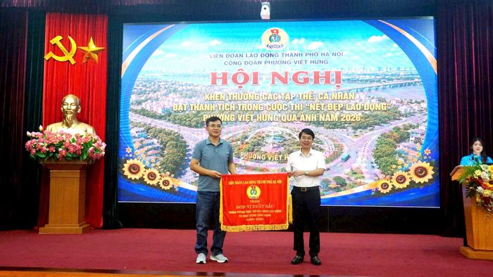 Chủ tịch Ủy ban MTTQ Việt Nam phường Việt Hưng Nguyễn Trường Giang tặng Cờ thi đua của LĐLĐ thành phố Hà Nội cho Công đoàn Công ty TNHH MTV Chiếu sáng và Thiết bị đô thị. Ảnh: B.Duy