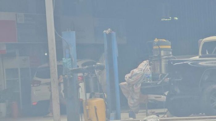 Bên trong một gara khác, xe ô tô được tháo dỡ để sửa chữa dưới hệ thống nhà xưởng kết cấu đơn giản bằng khung thép, mái tôn. Đây là dạng công trình tạm nhưng vẫn được sử dụng thường xuyên để kinh doanh dịch vụ kỹ thuật có nguy cơ phát sinh tia lửa điện và hóa chất dễ cháy.