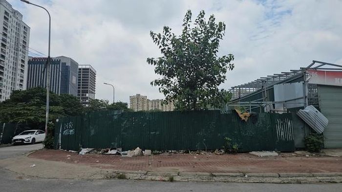 Trái ngược với những gara còn hoạt động, nhiều khu vực lân cận đã được phá dỡ hoàn toàn. Sau hàng rào tôn chỉ còn những bãi đất trống, vật liệu xây dựng ngổn ngang và cây cối mọc xen kẽ, cho thấy quá trình thu hồi, giải phóng mặt bằng đang được triển khai nhưng chưa đồng bộ.