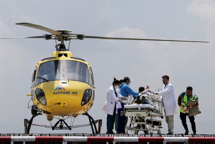 Các nhân viên y tế vận chuyển Dawa Sherpa từ sân bay trực thăng tại Bệnh viện HAMS ở Kathmandu, Nepal. Ảnh: Reuters.