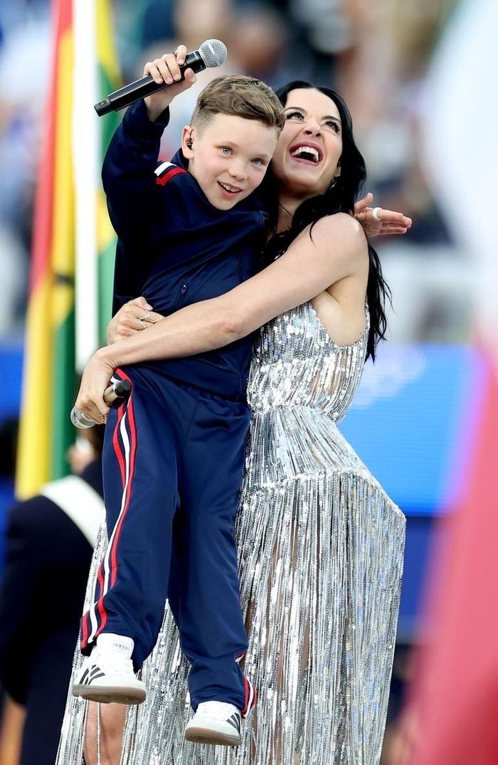  Để tham gia sự kiện đặc biệt này, Tius Luka đã di chuyển từ Na Uy đến Los Angeles và cùng Katy Perry xuất hiện trên sân khấu trước hàng chục nghìn khán giả. Màn kết hợp giữa ngôi sao nhạc pop và cậu bé mang đến khoảnh khắc giàu cảm xúc, góp phần tạo nên điểm nhấn khác biệt cho chương trình khai mạc. Bên cạnh những tiết mục sôi động của Lisa, Anitta hay Rema, phần trình diễn của Katy Perry được đánh giá cao nhờ thông điệp tích cực về sự kết nối, niềm tin và ước mơ. Ảnh: CHRIS TORRES/EPA/Shutterstock. 