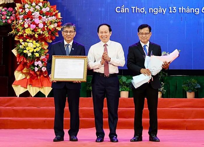 Phó Thủ tướng Lê Tiến Châu trao quyết định sáp nhập và tặng hoa chúc mừng Đại học Cần Thơ - Ảnh: VGP/Thu Sa